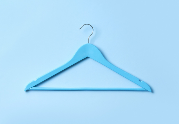 Top view flat lay single white wooden hanger blue pastel background. - Photo, Image