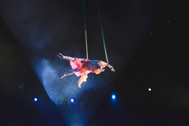 Aerial acrobat in the ring. A young girl performs the acrobatic elements in the air ring. - Fotoğraf, Görsel