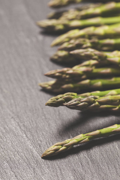 Fresh asparagus on a rustic slate background - 写真・画像