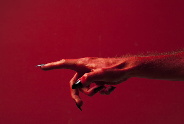 Halloween red devil monster hand with black fingernails against  - Fotografie, Obrázek