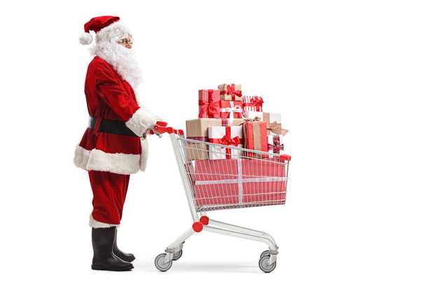 Santa Claus carrying presents in a shopping cart  - Valokuva, kuva