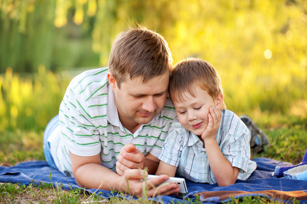 Apa és fia-val egy smartphone a szabadban - Fotó, kép