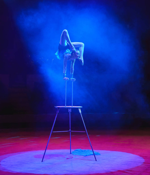 Légi Akrobata a ringben. Egy fiatal lány végez az akrobatikus elemeket a levegőbe, gyűrű - Fotó, kép