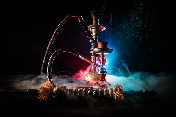 Wasserpfeife mit glühenden Kohlen auf Shisha-Schüssel auf dunklem, nebeligen Hintergrund. stilvolle orientalische Shisha. - Foto, Bild