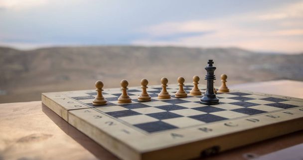 Sakktábla játék fogalmát az üzleti ötletek és a versenyt. Sakkfigurák egy sakktáblán. Kültéri naplemente háttér. - Fotó, kép