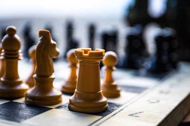 ビジネスのアイデアと競争のチェスボードゲームの概念。チェスボードの上のチェスの数字。屋外の夕日の背景. - 写真・画像