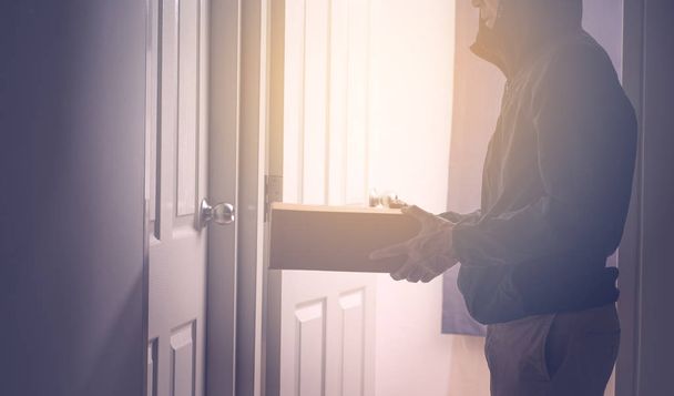 Unrecognize delivery man with box of pardel at the door - Фото, изображение