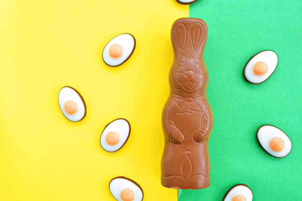 A húsvéti nyuszi készült csokoládé színes csokoládé chipek a külső fekszik egy egységes célú felszíni édességek Húsvét egy színes felületen - Fotó, kép