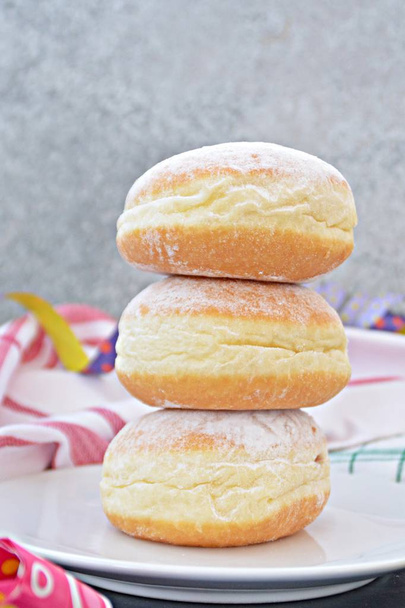 Os donuts tradicionais assados na Alemanha durante a temporada de carnaval estão em um prato e são polvilhados com açúcar em pó um conceito com o chamado Krapfen na época do carnaval na Alemanha.
  - Foto, Imagem