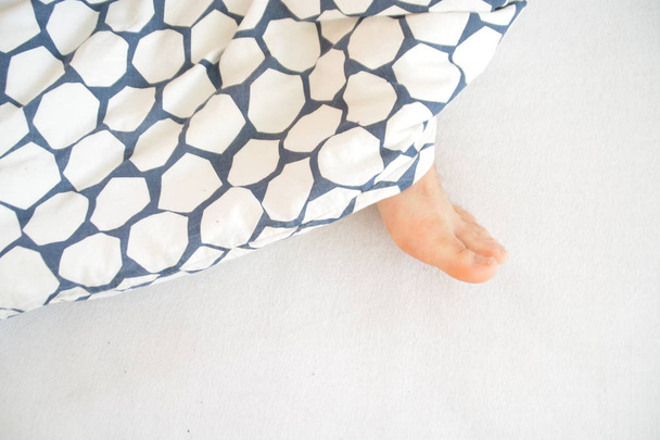 closeup view of legs sticking out from bed - Photo, Image