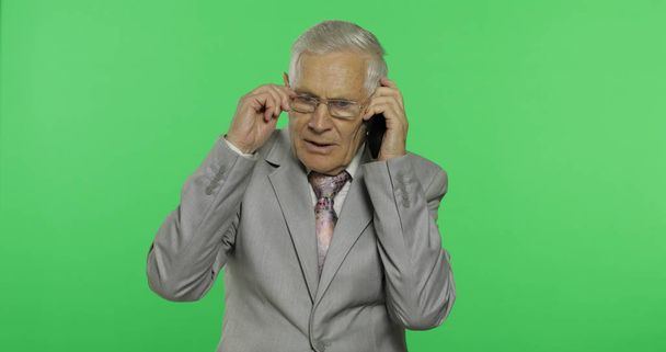 Der gut aussehende ältere Geschäftsmann spricht auf einem Smartphone. alter Mann im Anzug - Foto, Bild