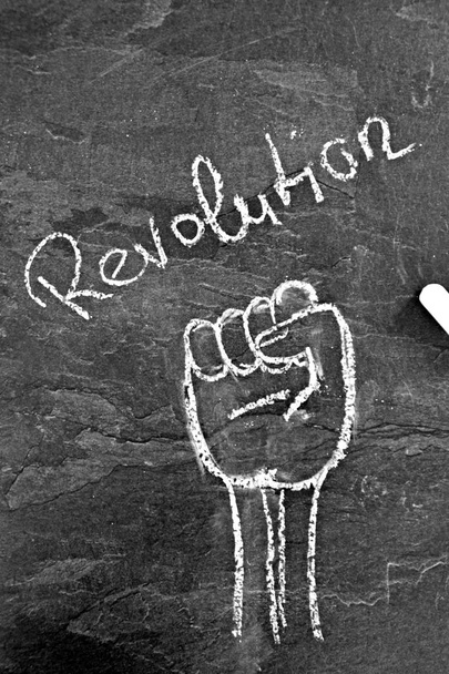 With chalk an outstretched fist was painted on a dark marble surface - symbol and symbol for revolution and demonstration drawn with chalk  - Photo, Image