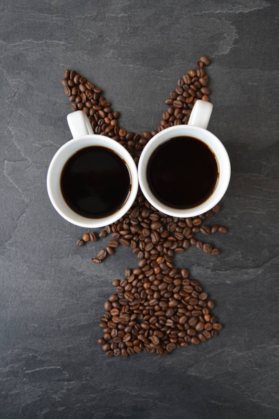 A húsvéti nyuszi készült frissen pörkölt kávébab lefektetett egy csésze kávé-koncepció a friss kávé élvezetet a húsvét és a húsvéti ajándék formájában kávébab - Fotó, kép