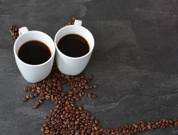 Ένα πασχαλινό λαγουδάκι φτιαγμένο από φρεσκοψημένα φασόλια καφέ που έχουν γίνει με ένα φλιτζάνι καφέ για απόλαυση φρέσκου καφέ το Πάσχα και ως Πασχαλινό δώρο με τη μορφή κόκκων καφέ - Φωτογραφία, εικόνα