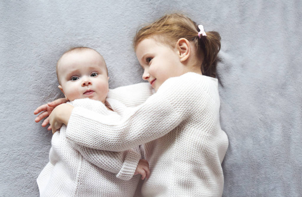 Lifestyle portrait of cute Caucasian girls sisters holding littl - Photo, Image