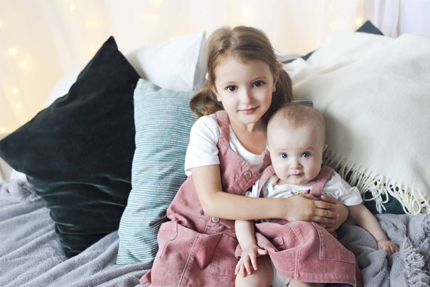 Lifestyle portrait of cute Caucasian girls sisters holding littl - Photo, image