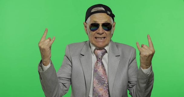 Grappige Senior zakenman in zonnebril tonen teken van de hoorns met zijn handen - Foto, afbeelding