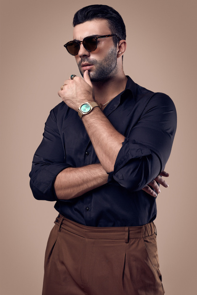 Bonito brutal bronzeado hipster homem em uma camisa preta e óculos
 - Foto, Imagem
