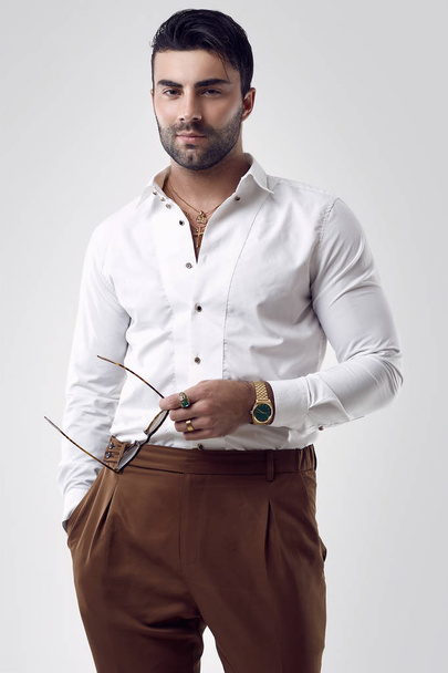 Beautiful brutal tanned businessman in a white shirt and sunglasses - Photo, Image