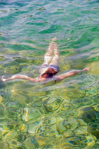 Young girl swiming in the sea - Fotó, kép