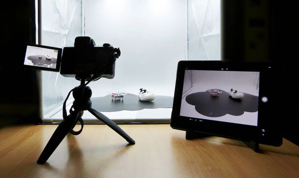 eine Studioaufnahme mit einem Leuchtkasten. Kamera auf Stativ, Tablet auf Kamera-Fernbedienung  - Foto, Bild