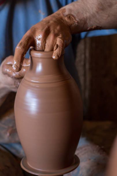 ceramic workshop - the man  makes a pot of clay on a potter's wh - Photo, Image