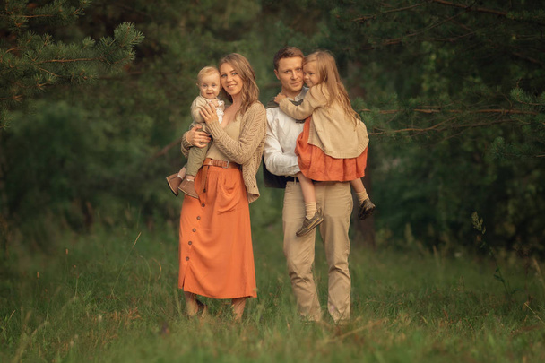Full Length shot of parents holding kids on the hands and looking at the camera  - Valokuva, kuva