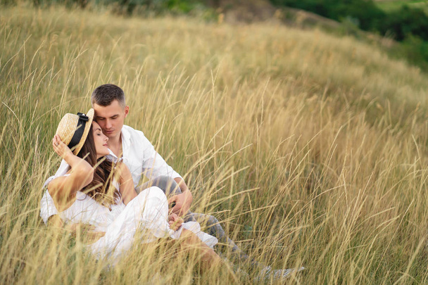 Man and woman relaxing together in the grass field in countrysid - 写真・画像