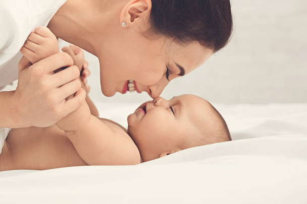 Mère et bébé qui touchent le nez au lit
 - Photo, image