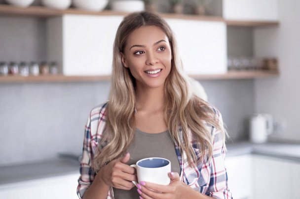 Щаслива молода жінка з чашкою кави
 - Фото, зображення