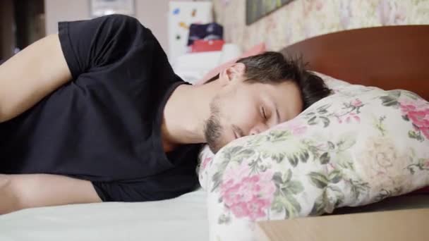 Homme aux cheveux foncés tombe sur le lit avec un oreiller confortable et s'endort immédiatement
. - Séquence, vidéo