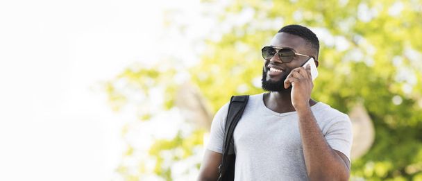 Portrait de l'homme africain élégant dans des lunettes de soleil parlant par téléphone
 - Photo, image