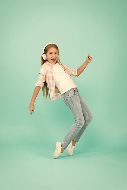 This song has the energy. Small girl listening to music in headphones. Dancing girl. Happy small girl dancing to music. Cute child enjoying happy dance music. Music is happiness for her - Photo, Image