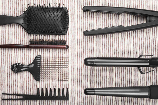 hair straightening tools lying near various combs - Foto, Imagen