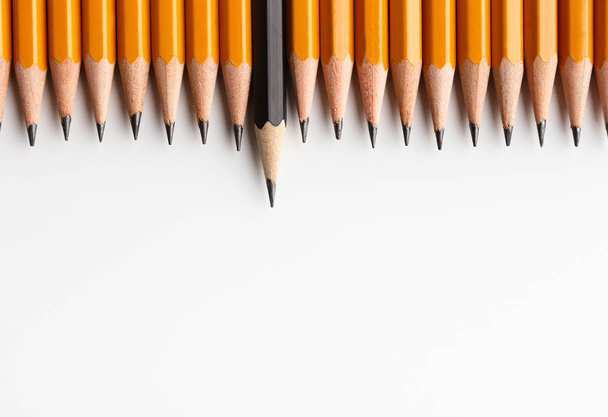 Row of classic yellow pencils with one black protruding - Photo, Image