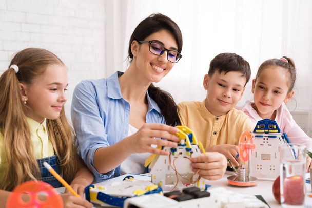 Bambini che costruiscono robot con insegnante in classe
 - Foto, immagini
