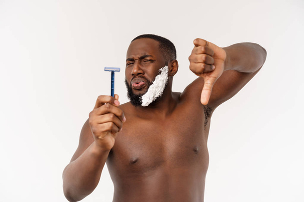 Νέος αφροαμερικανός άνθρωπος ξύρισμα στο μπάνιο. Προσωπική πρωινή ρουτίνα. Υγιεινή στο πρωινό concept. - Φωτογραφία, εικόνα