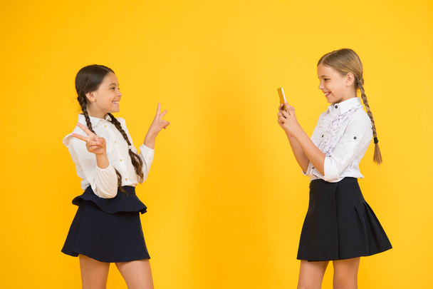 blogging. back to school. educational blog. new technology. online education. knowledge day. happy pupils with smartphone. kids make photo, friendship. small girls in school uniform - 写真・画像