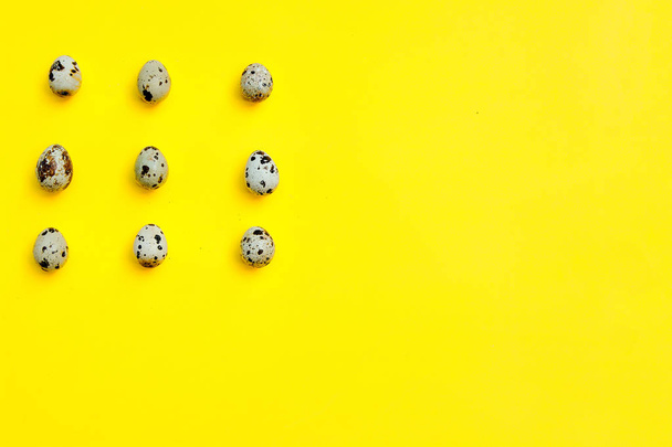 Set of group quail eggs in a row on a yellow background. - Photo, Image