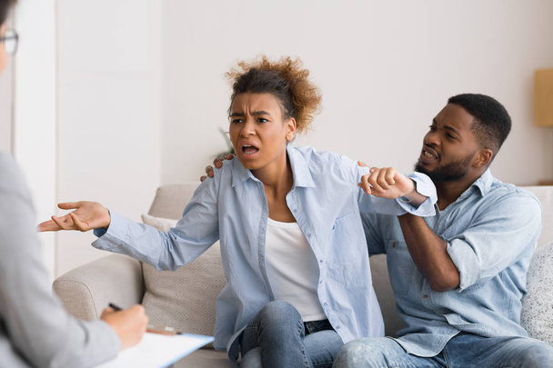 Emocional afro mujer agitando las manos y culpando a marido durante la psicoterapia
. - Foto, imagen