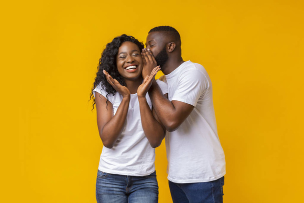 Afro Guy fluisteren geheimen aan zijn vriendin - Foto, afbeelding