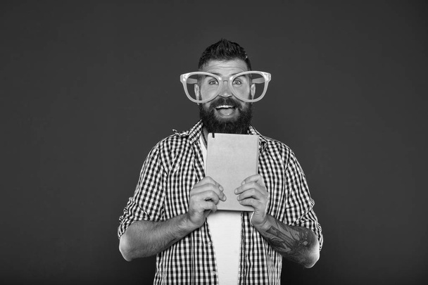 Nerdy and funny. University male student with lecture notes. Study nerd holding book. Book nerd wearing fancy glasses. Bearded man in party glasses with lesson book - Fotografie, Obrázek