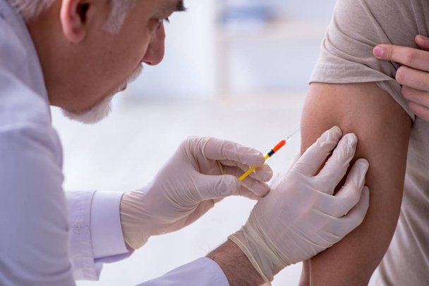 Patient masculin médecin visiteur pour injection d'inoculation  - Photo, image