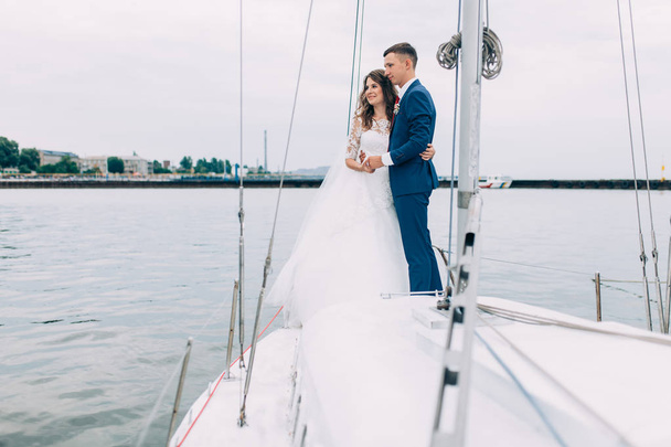 Wedding couple on the yacht, lovers posing on the yacht - 写真・画像