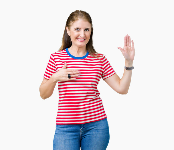 Взрослая женщина средних лет носит повседневную футболку на изолированном фоне, ругаясь рукой на груди и открытой ладони, давая клятву верности
 - Фото, изображение