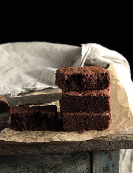 стопка запечених квадратних шматочків шоколадного пирога на коричневому
  - Фото, зображення