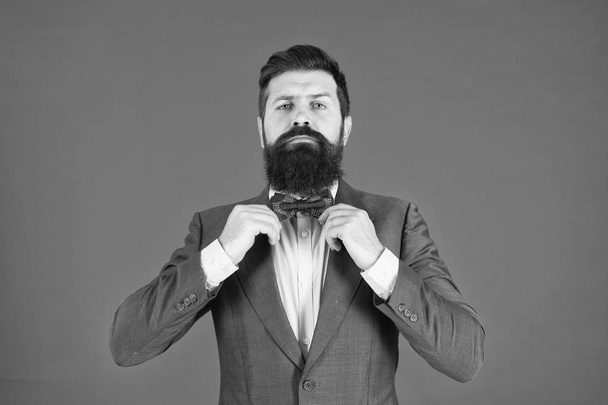Man bearded hipster wear classic suit outfit. Formal outfit. Take good care of suit. Elegancy and male style. Businessman or host fashionable outfit on red background. Fashion concept. Classy style - 写真・画像