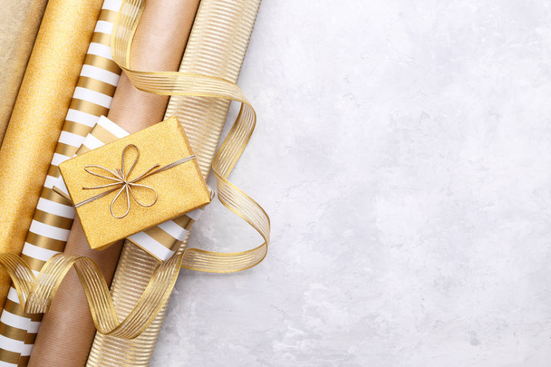 Golden glossy wrapping paper rolls and gift boxes - Foto, Bild
