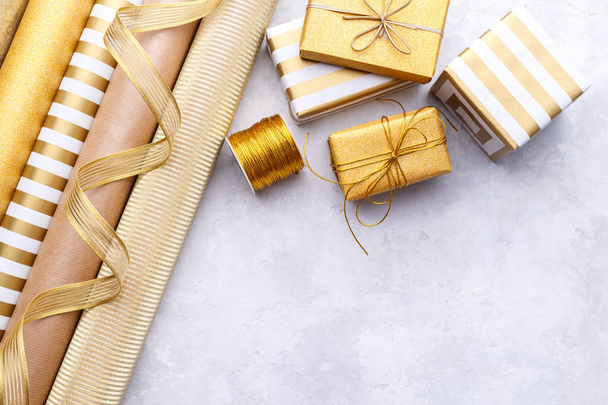 Rollos de papel de regalo dorados brillantes y cajas de regalo
 - Foto, Imagen