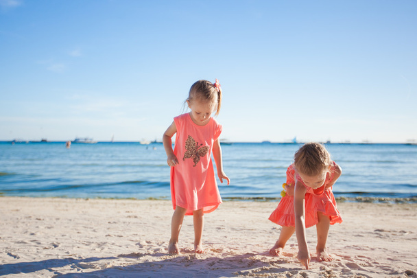 Two little sisters playing together on the white beach - Photo, Image